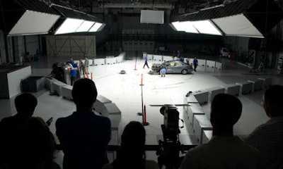 People on the observation deck watch as engineers inspect a car after a crash test at the Vehicle Research Center (VRC). The VRC was the site of today's announcement regarding automatic emergency braking.