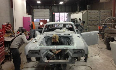 The staff of Ink & Iron, hard at work on the custom '63 Lincoln that will be on display at the Kreator Custom Motorcycles booth.