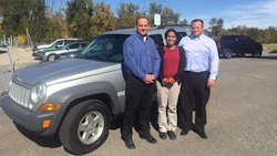 CARSTAR Okotoks' Director of Operations Andrew Northrup (left) is pictured alongside his colleague Curtis Williams (right) as they officially hand Ana Sosa's (middle) fully-repaired 2005 Jeep Patriot back over.