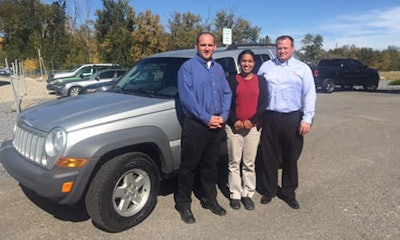 CARSTAR Okotoks' Director of Operations Andrew Northrup (left) is pictured alongside his colleague Curtis Williams (right) as they officially hand Ana Sosa's (middle) fully-repaired 2005 Jeep Patriot back over.