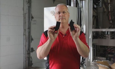 Carl Dumele, CEO of Aeromotive holds up two parts for a visual inspection. The part on the left is the original, damaged bracket. The one on your right is a new part Aeromotive turned out with its 3D printer.