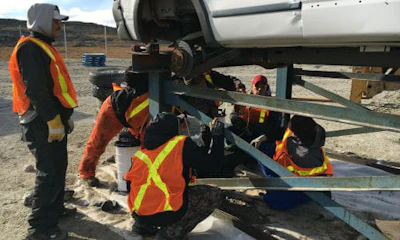 Local hires in Kangirsuk receiving in-field training from volunteer auto recycler, Ken Edwards from Peterboro Auto Recyclers.