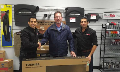 A lucky winner with his new big screen TV. Draws for the TVs and other prizes were held at each location.