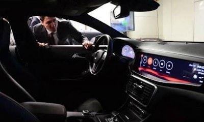 Prime Minister Justin Trudeau examines a vehicle at the Blackberry QNX facility.