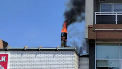 Flames pour from the exhaust system on the roof of Scotty's Auto Body in Ottawa. Photo by Francis Lavoie.