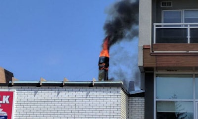 Flames pour from the exhaust system on the roof of Scotty's Auto Body in Ottawa. Photo by Francis Lavoie.