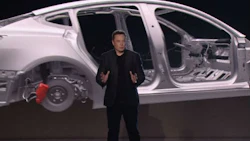 Tesla's founder Elon Musk stands in front of a rendering of the company's Model 3 body-in-white. It's been speculated that Tesla's first mass-market car will use a mixed-material construction.