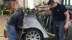 Johnny D'Ambrosio, co-owner of Fix Auto St. Catharines, working with a young technician. The shop has fostered a culture that encourages young people to stay and advance.