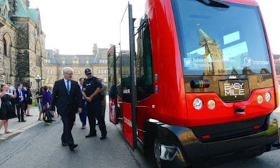 Transport Minister Marc Garneau prepares to board an automated bus built by TransDev during a demonstration on Parliament Hill on Wednesday.