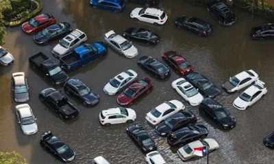 Cars are pushed together during heavy flooding in the center of a hotel compound, in Houston, Texas. Some of the aftereffects of Hurricane Harvey will likely include an increase in new car sales, and a rash of 'title washing' as owners of uninsured vehicles try to recoup their losses.