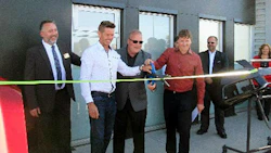Dave Miller and Mike Davis cutting the ribbon at the official grand opening of Fix Auto Airdrie. Davis and Miller are also co-owners of facilities in Calgary and Lethbridge.
