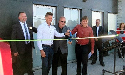 Dave Miller and Mike Davis cutting the ribbon at the official grand opening of Fix Auto Airdrie. Davis and Miller are also co-owners of facilities in Calgary and Lethbridge.