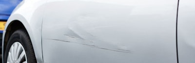Detail Of Damage To Door Of Vehicle In Car Park With Scratched Panel