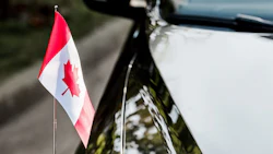selective focus of canadian flag with maple leaf on black car