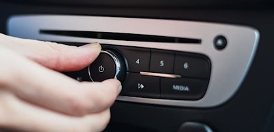 Hand press on button on the car radio, close up