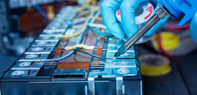 Technician use soldering iron to solder metal and wire of lithiu