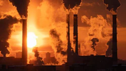 Air pollution and global warming. Smoking chimneys of thermal power plant at sunset in winter city