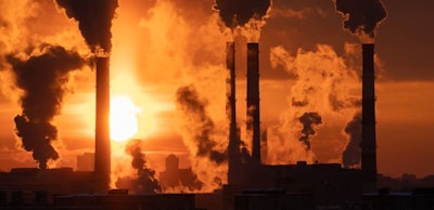 Air pollution and global warming. Smoking chimneys of thermal power plant at sunset in winter city
