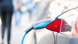 An electric car is charged with energy by a road dispenser