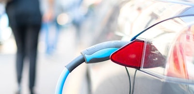 An electric car is charged with energy by a road dispenser