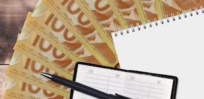 100 Canadian dollars bills fan and notepad with contact book and black pen. Concept of financial planning and business strategy