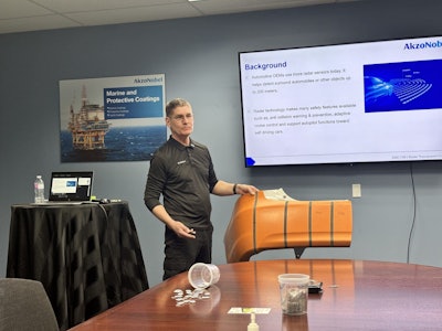 Brad Kruhlak of AkzoNobel demonstrates the location of radar sensors in modern car bumpers.