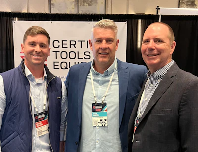 Three professionals at industry conference with certification tools banner