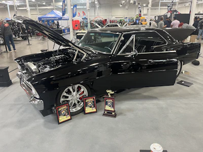 Restored black muscle car with awards at automotive exhibition