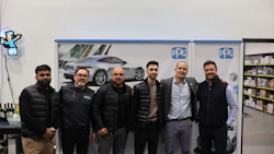 PPG team of six professionals posing in warehouse with sports car backdrop