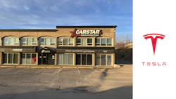 CARSTAR auto repair shop exterior with parking lot under clear blue sky