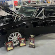 Black classic muscle car with chrome wheels and show awards at automotive exhibition