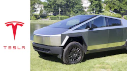 Tesla Cybertruck parked on grass near water, showcasing futuristic angular design
