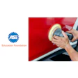 Automotive technician polishing red car panel with orbital buffer