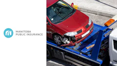 Damaged red car being towed on blue flatbed after collision