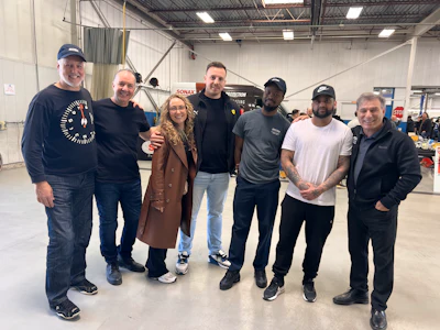 Diverse team of professionals posing together in industrial workspace