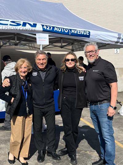 CSN 427 Auto Avenue team posing together at outdoor event under branded tent