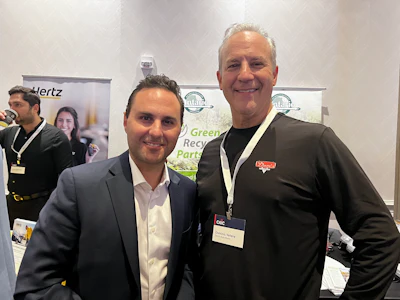 Professionals networking at automotive industry conference with trade show displays