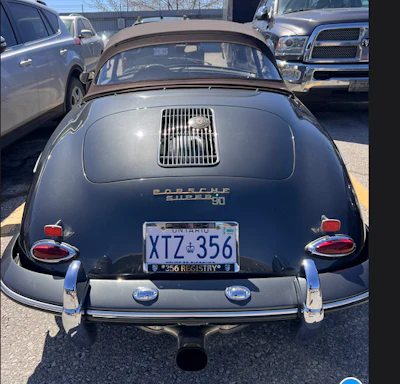 Vintage navy blue Porsche 356 convertible with chrome details, rear view