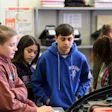 Students studying automotive mechanics in a workshop classroom