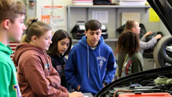 Students studying automotive mechanics in a workshop classroom