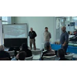 BMW collision repair training seminar with presenters and automotive workshop projection