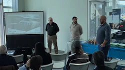 BMW collision repair training seminar with presenters and automotive workshop projection