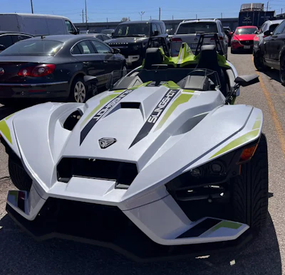 White and green Polaris Slingshot three-wheeled performance vehicle