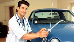 Doctor performing medical procedure near blue vehicle indoors