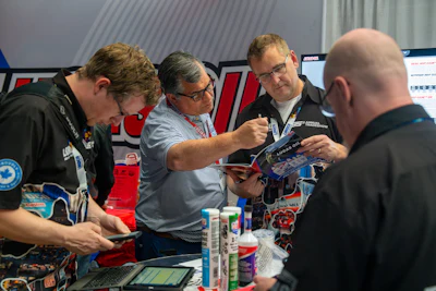 Technical professionals reviewing product materials at industry trade show booth