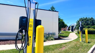 Electric vehicle charging station with yellow Aviva charging pillars on a sunny day