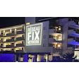 Modern building at night with Réseau Fix Network illuminated logo on white facade