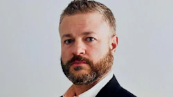Professional businessman in dark suit with beard looking directly at camera