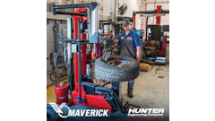 Technician operating Maverick tire changing machine in automotive workshop