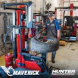 Technician operating Maverick tire changing machine in automotive workshop